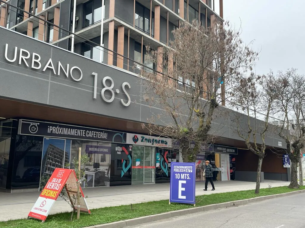 Fachada con la señal de estacionamiento público a 10 metros